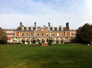 view of neo-classical brick building with stone pointing and large chimneys