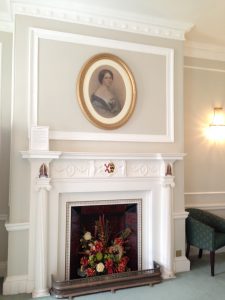 square design fireplace with oval lady's portrait above
