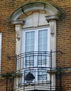 arched broken pediment and balcony over window