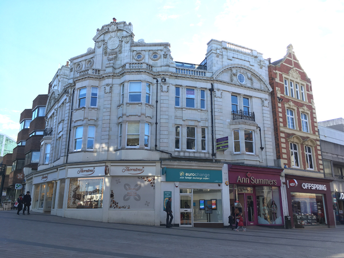 Ornate white stone fronted shop with carved details