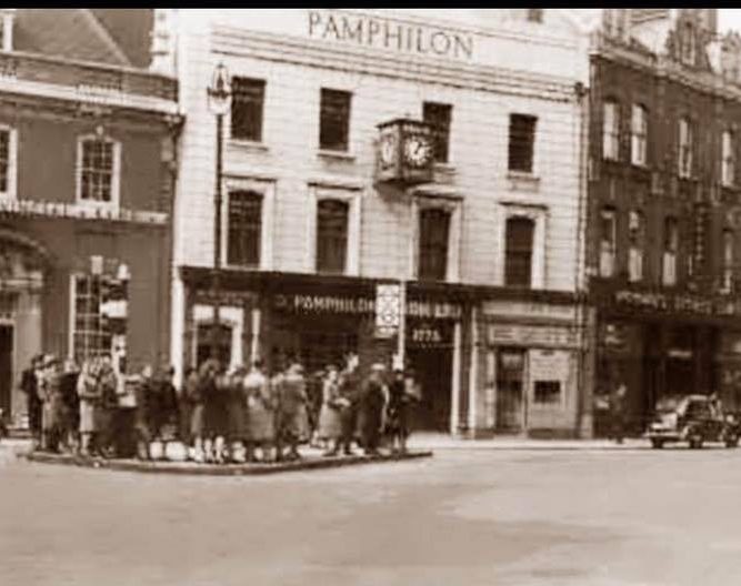 the georgian building behind traffic island with women on