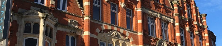 extravagant shop front striped brick and oriel window