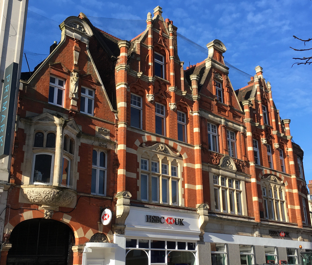 extravagant shop front striped brick and oriel window