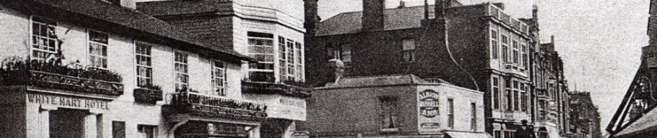 street scene from 1900s with hostelry on one side and hackney carraige