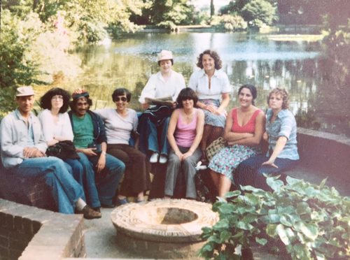 group of students sitting around a circular stone
