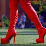 Pair of red boots walking over artifical turf